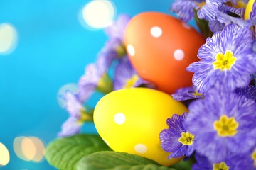 Obraz na płótnie Canvas Easter concept. Easter motley eggs on a bright blue background with golden bokeh.Holiday Easter spring bright background.Spring Religious holiday