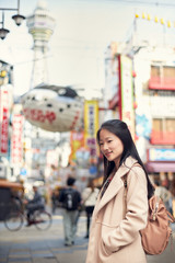 Asian young woman is traveling at Shinsekai, Osaka, Japan.