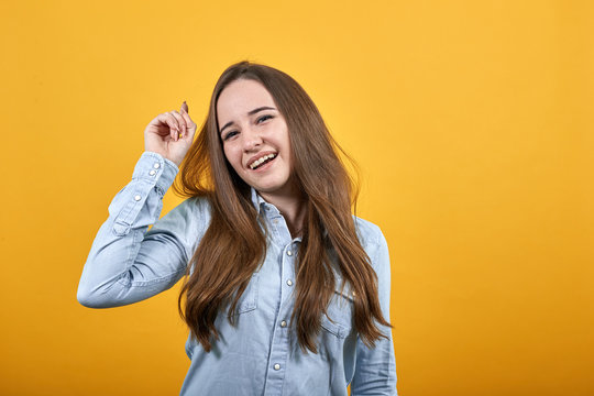 Cheerful happy lady wearing fashion shirt isolated on orange background in studio dancing, smiling. People emotions, lifestyle concept.