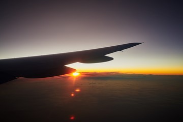 Sunrise and horizon cloudy sky in morning, view from airplane window