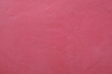Red, pink cement wall exterior decoration outside of the building. Colorful wall decoration artwork with natural concrete surface stained with color pigment, idea for valentine wallpaper, background.
