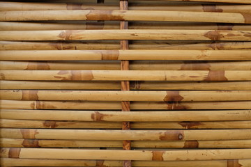 Dry horizontal yellow bamboo wallpaper. Exterior home decoration in Asian country, Japanese, Chinese. Nature construction material. Background and surface, wallpaper concept.