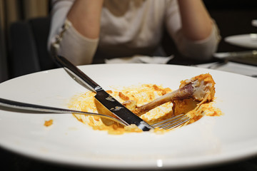 Dirty plate with appliances and bone on the table.