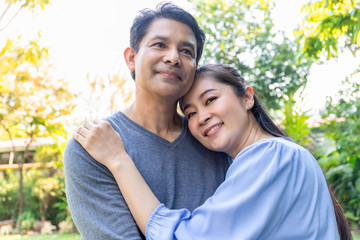Senior Asian couple embrace together at the garden.