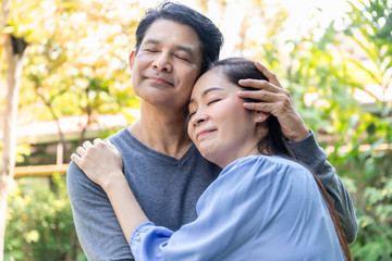 Senior Asian couple embrace together at the garden.