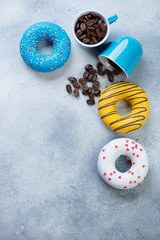 Light-blue stone background with coffee and donuts. Vertical shot with copy space, flatlay
