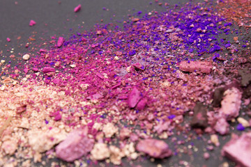 Fototapeta na wymiar This is a photograph of nude,brown,blue,pink and purple matte and shimmery powder Eyeshadow on a Black background