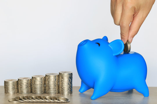 Blue piggy bank and stack of coins money on wooder background, Saving money for prepare in future and investment concept