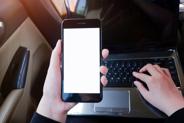 Cropped shot view of young businesswoman using laptop and smart phone  in a car.
