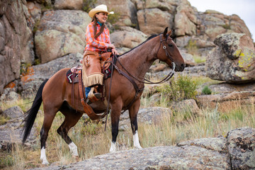 Obraz premium Cowgirl Riding on Rocks