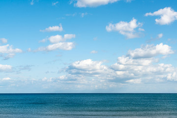 Naklejka na ściany i meble Ocean skyline with blue sky and white cloudy, natural landscape background