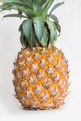 A pineapple stands alone on a white background.