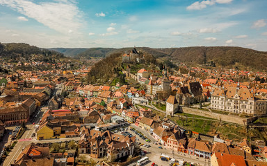 Drone shot of the old town of Sighisoara in the afternoon during spring season . One of the most beautiful city which is Unesco sites of the country , Sighisoara , Transylvania , Romania