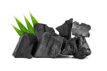 Obraz premium Natural wooden charcoal, Traditional or hard wood charcoal with bamboo leaves isolated on white background.