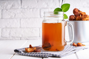 Homemade lemonade of dried fruits in a jar on a light table.
