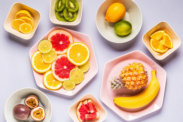 Tropical fruits whole and slices on plates