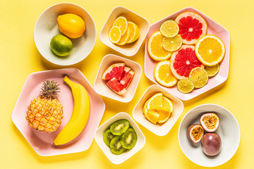 Tropical fruits whole and slices on plates
