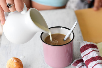 Coffee and milk on the table. Pouring milk into coffee/latte/ Breakfast table-starting a day 
