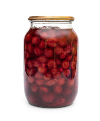 Glass jar with canned cherry on white background.