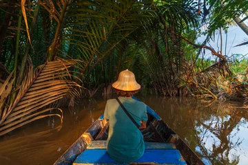 Foto op Canvas Boat tour in the Mekong River Delta region, Ben Tre, South Vietnam. Tourist with vietnamese hat on cruise in the water canals through coconut palm trees plantation. © fabio lamanna