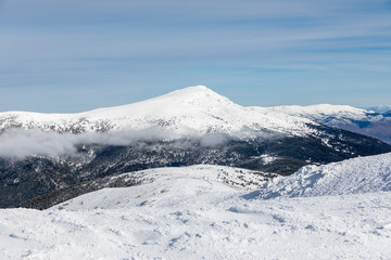 Fototapeta na wymiar Snowy mountains in the Sierra de Guadarrama of Madrid seen from the ascent to Guarramillas