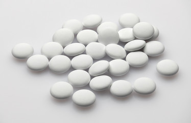 Group of white pills on white background - healthcare and medicament concept. Pharmaceutical industry. Pharmacy.