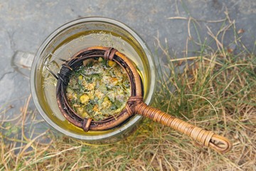 Fototapeta na wymiar Cup of herb tea in bamboo strainer