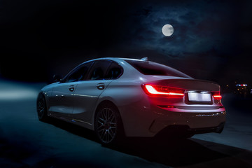Fototapeta na wymiar Car moves on the road on a moonlit night.