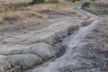 Dirt road impassable in the field blurred by rains