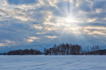 sunset over the lake covered with ice in winter