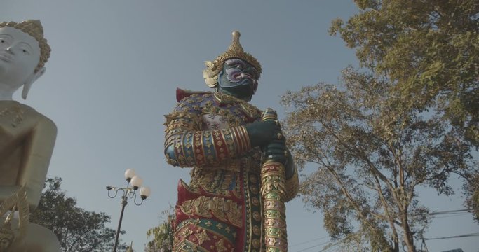 Buddhist statue with trees and big buddha filmed in 4k with camera movement in slow motion at a buddhist temple in Chiang Mai, Thailand - Slow motion