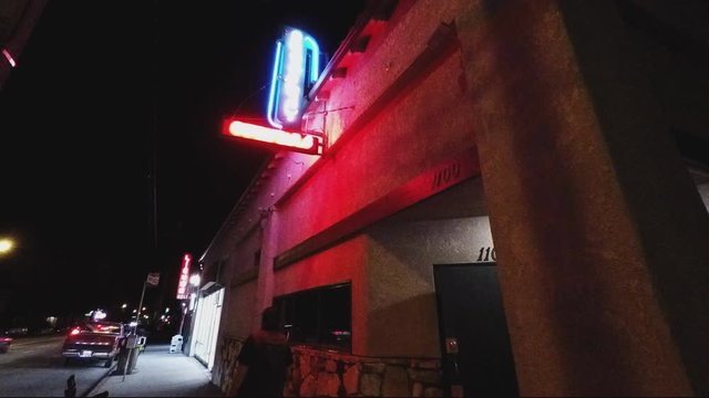 Man Exits And Walks From Generic Tavern Bar Pub- Night