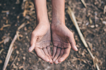 hands poor child or beggar begging you for help sitting at dirty slum. concept for poverty or hunger people,human rights,donate and charity for underprivileged children in third world 