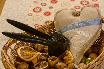 christmas still life with small basket full of walnuts, dryed lemons, decorations and nutcracker