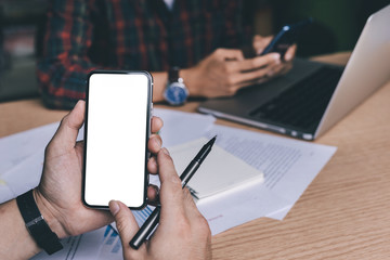 Mockup image blank white screen cell phone.man hand holding texting using mobile on desk at office.background empty space for advertise text.people contact marketing business,technology 
