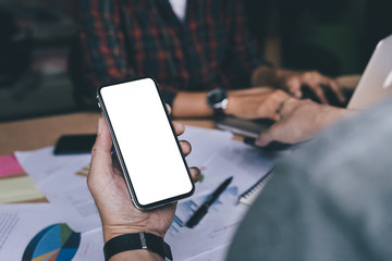 Mockup image blank white screen cell phone.man hand holding texting using mobile on desk at office.background empty space for advertise text.people contact marketing business,technology 