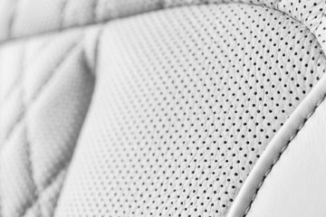 Modern luxury Car white leather interior. Part of perforated leather car seat details. White...