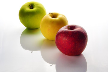Apples green, yellow and red on a white background.