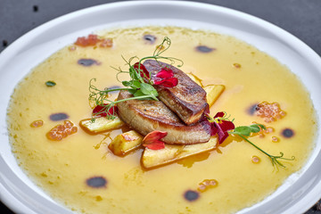 Foie gras with sauce, on a white plate © pobaralia