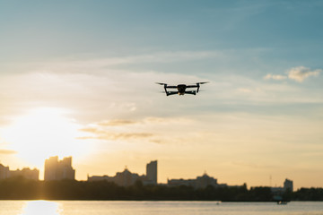 Fototapeta na wymiar Drone flying over the river beach at the sunset with cityscape at the background