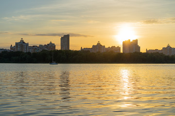 River beach at the sunset with cityscape at the background