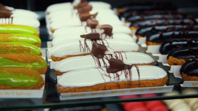 Tasty choux pastry lying at shop showcase. Macro of flavor cakes at patisserie.