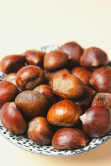 A nice bowl of chestnuts on beige background