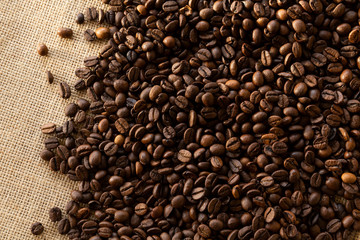 Fototapeta na wymiar Structured linen background with roasted coffee beans