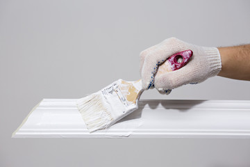 Painting the skirting Board with a white paint brush