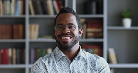 Happy african american businessman looking at camera in office, portrait - Powered by Adobe