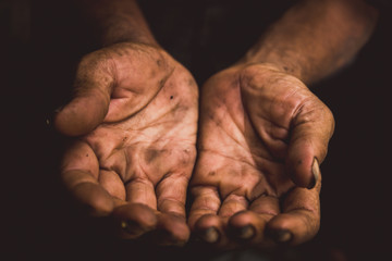 hands poor man or beggar begging you for help sitting at dirty slum. concept for poverty or hunger people,human rights,donate and charity for underprivileged people in third world