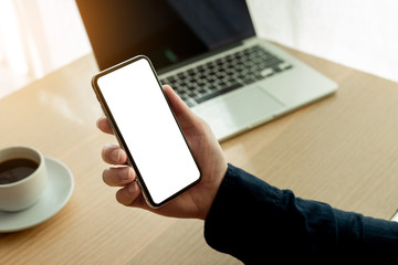 Mockup image blank white screen cell phone.man hand holding texting using mobile on desk at office.background empty space for advertise text.people contact marketing business,technology 