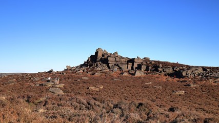 Over Owler Tor on Hathersage Moor in the English Peak District under beautiful blue skies