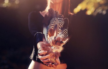 Shaman woman and shamanic feathers on denim.